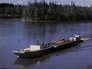 A shallow draft boat pushing barges past Bitumount, n.d.<br/>Source: University of Alberta Archives