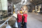 School children read the newly installed interpretive panels at the Turner Valley Gas Plant Historic Site during the centennial celebration, May 2014. <br />Source: Alberta Culture and Tourism