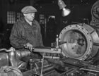 A machinist works on a compressor, n.d. Skilled workers repaired old and created new equipment for use in the oil field and at the gas plant. <br />Source: Provincial Archives of Alberta, P3180