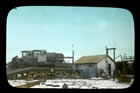 A small tanker truck unloads its cargo of oil at Okotoks, ca. 1925. Note the railway tanker cars at right side of the image. Presumably, this oil would be transported by rail to Calgary. <br />Source: Glenbow Archives, S-17-101