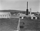 The original Royalite absorption, compression and scrubbing plant, ca. 1926; the Royalite plant was the second scrubbing operation in Canada and followed a precedent set in Ontario based on a process originally developed in the United States to clean up coal gas. Toxic hydrogen sulfide was removed from the sour gas, yet there was little that could be done with it except push it up into the atmosphere. This gave the area a distinct aroma: "You could smell Turner Valley as you were driving out from Calgary. You could smell it in Calgary if the wind was right. Like rotten eggs.". Source: Provincial Archives of Alberta, P1882