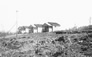 Latrine, right, behind staff houses on the edge of the Alberta Government Oil Sands Project site, ca. 1946<br/>Source: University of Alberta Archives, 83-160-76