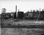 Storage tank (far left) at the abandoned International Bitumen Company site, ca. 1951<br/>Source: Provincial Archives of Alberta, PR1991.0539.14