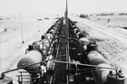 Oil tanker railway cars being loaded at Imperial Oil’s pipeline terminal, near Redwater, 1949; the oil field at Redwater was large and productive, necessitating the expansion of rail and pipeline facilities in the area.