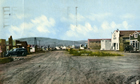 Main street in "Little New York" (later named Longview), near Turner Valley, ca. 1940s; ramshackle communities such as this grew quickly in Alberta’s oil fields. Little had changed in Little New York in the twenty or so years of its existence. Note the rough condition of the road, the "boom town" facades on many buildings and the oil derrick just off the main street.