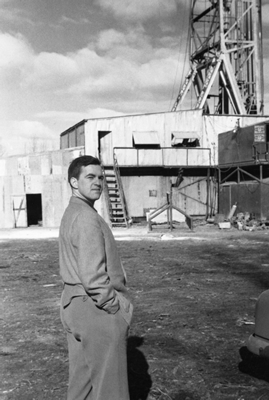 A well-site geologist stands in front of the Pembina No. 1 well, 1953. Source: Glenbow Archives, NA-5103-9