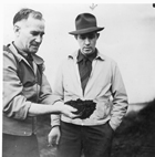 Robert Fitzsimmons shows Lloyd Champion a sample of the oil sands at the Bitumount quarry, n.d.<br/>Source: University of Alberta Archives, 83-160-113