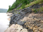 Bitumen seeps from limestone banks along the Athabasca River such as the early fur traders described. Source: Larcina Energy