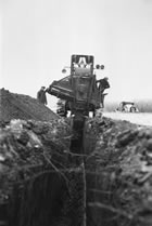 View of pipeline construction showing trench digging machinery, Turner Valley, Alberta, May 1938; expansion at the Turner Valley gas plant required increased capacity to transport gas to Calgary. <br />Source: Glenbow Archives, IP-6e-1-58