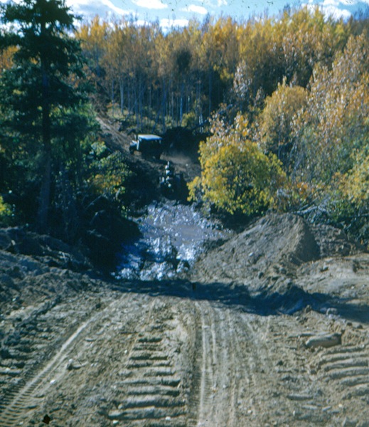 Low spots were often boggy. This Jeep had back-up, in the form of a tractor with tracks, in case it got stuck, ca. 1950.
