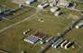 This aerial view of the Turner Valley Gas Plant Historic Site shows above-ground tanks at left, a fan tank to the left of the overhead pipeline, and four butane or propane tanks to the right, n.d. <br />Source: Alberta Culture and Tourism, AB070914312