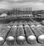 Storage tanks, ca. 1946-1947; the 1930s boiler house, demolished in the 1960s, is in the background. <br />Source: Glenbow Archives, IP-14a-2598