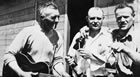 Workers enjoy a moment of leisure outside their bunkhouse in Longview, late 1930s. <br />Source: Glenbow Archives, NA-4614-23