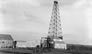 The derrick at the Dingman No. 2 well of Calgary Petroleum Products is being assembled, 1914. Note that the walking beam, which raised and dropped the drill bit in the hole, projects from the derrick, not yet attached to a drive mechanism. <br />Source: Glenbow Archives, NA-5262-23
