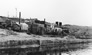 International Bitumen Company boiler house, white building at left, 1930s<br/>Source: Suncor, Bitumount, 1930s