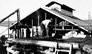 Hand shoveling oil sand into the hopper at the International Bitumen Company separation plant, ca. 1930<br/>Source: Provincial Archives of Alberta, PR1968.0015.24-14