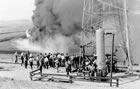 Professor J. A. Allan organized the University of Alberta geology field school, which gave geology students practical experience as well as academic knowledge. The field school is pictured in Turner Valley with gas flaring near a drilling rig, 1939. <br />Source: University of Alberta Archives, UAA 79-23-2135