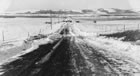 A cleared road through Turner Valley leads to the Royalite No. 4 well, ca. 1924. The road network through Turner Valley was almost non-existent during the early years of the plant’s development. It would take years for better transportation infrastructure to develop. <br />Source: Glenbow Archives, IP-6e-3-70