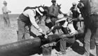 Sealing joints on sections of pipeline that have been bolted together, ca. 1920-1929 <br />Source: Glenbow Archives, NA-4859-9